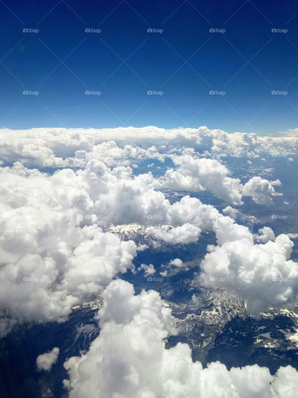 Beautiful clouds in the sky. White, fluffy, sunny day, summer time, amazing mountains below. 