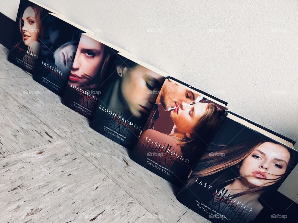 Vampire Academy by Richelle Mead. The books in order are : Vampire Academy, Frostbite, Shadow Kissed, Blood Promise, Spirit Bound, & Last Sacrifice. 