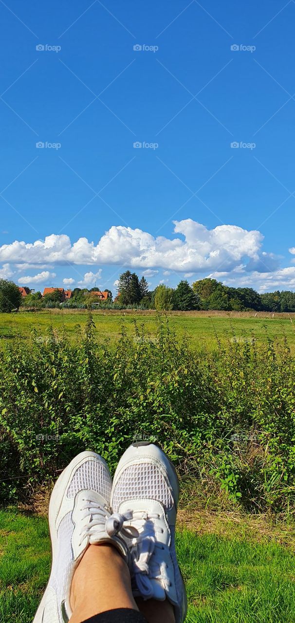 white clouds, green field and my white sneakers