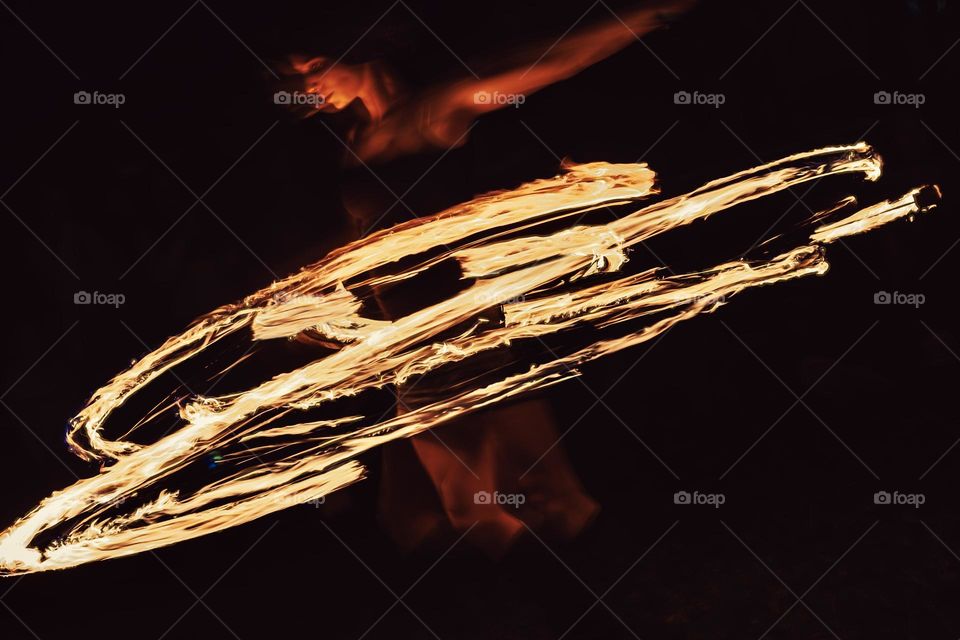 A woman performs with a fire staff