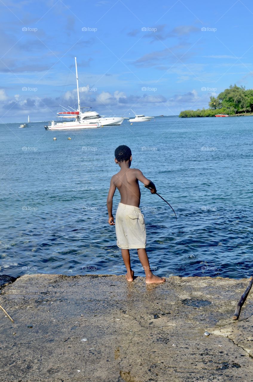A small boy trying to catch fish