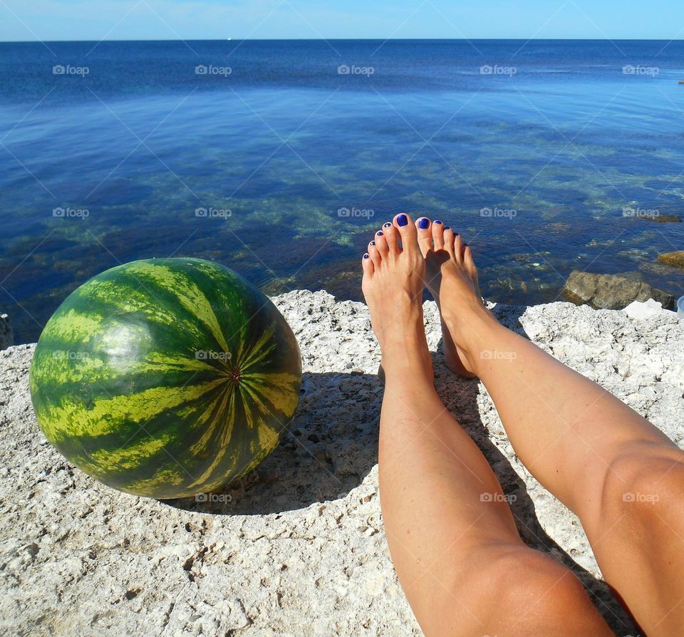 round watermelon and female legs
