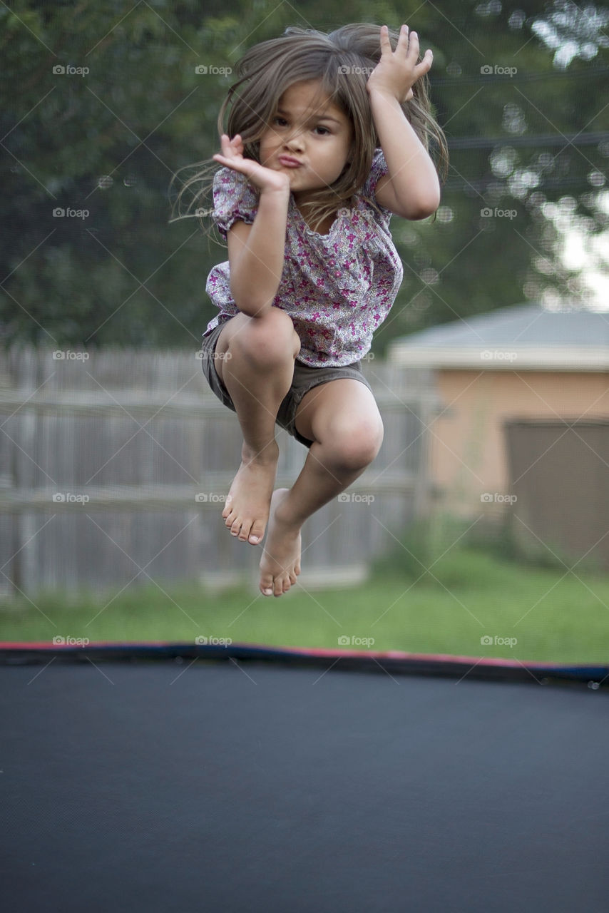 Small kid jumping on trampoline