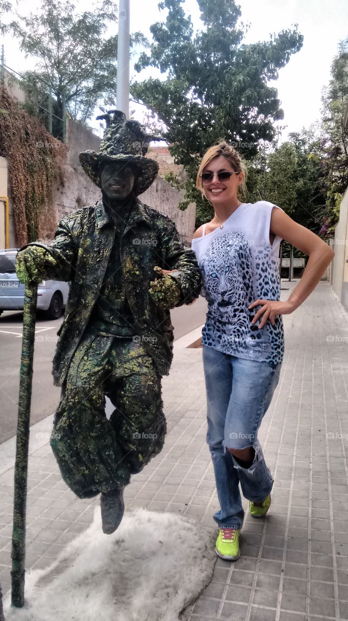 Woman posing with man dress as statue