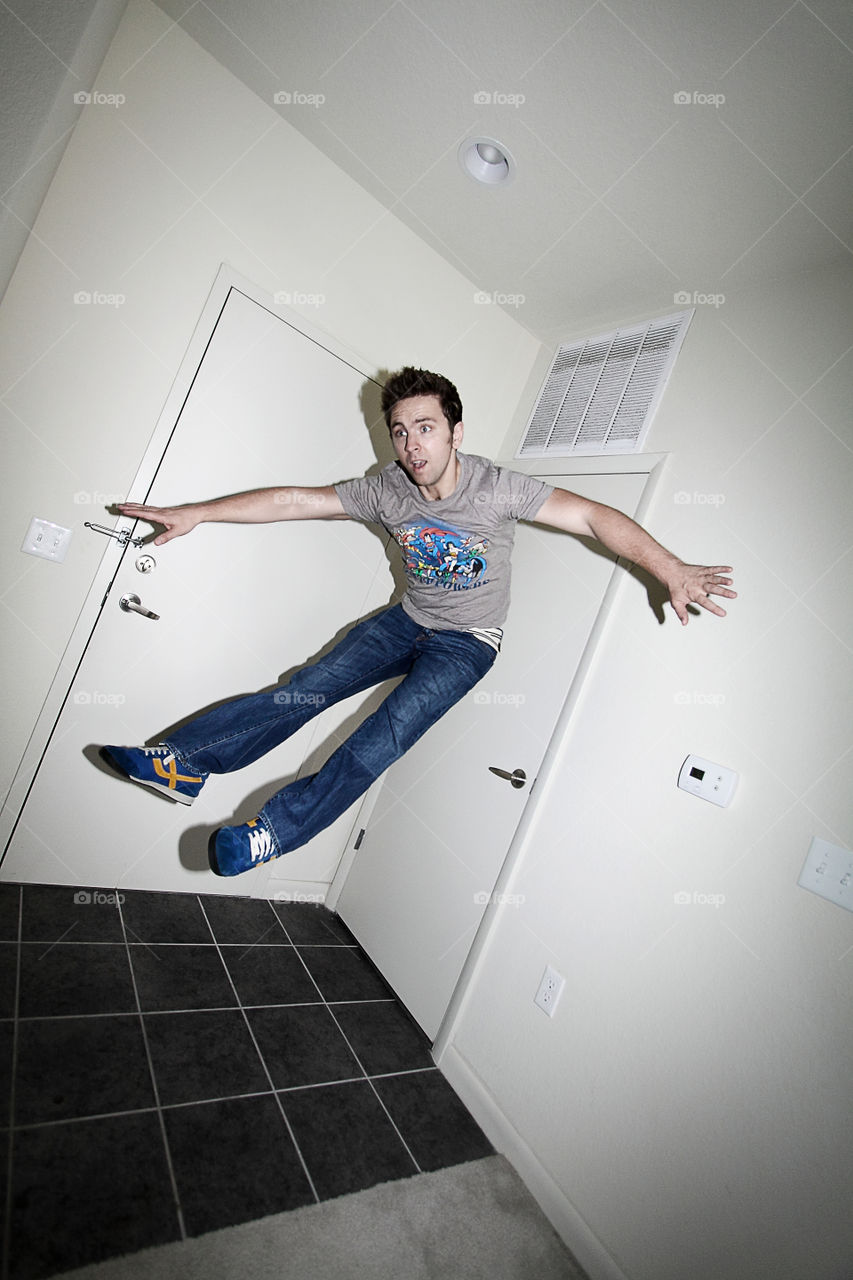Young man jumping in front of door