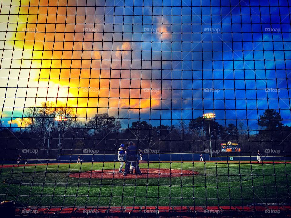 Rain clouds giving way to sunlight at a baseball game.