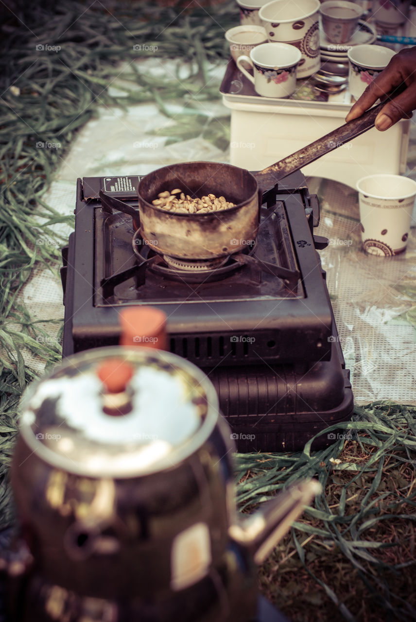 Fresh burned coffee beans. Iternational BBQ. Friend from Eritrea prepare for us coffee with a traditional coffee drinking culture.