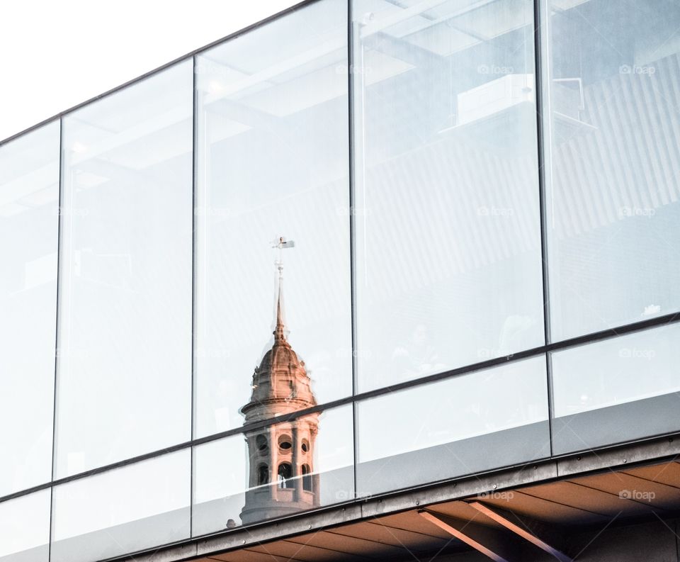 Bell Tower reflecting in modern building 