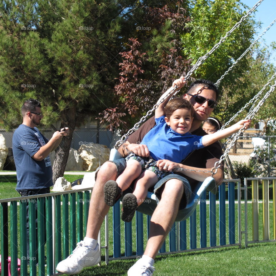 Father and son enjoying on swing