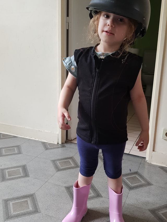 funy little girl with her sister riding clothes