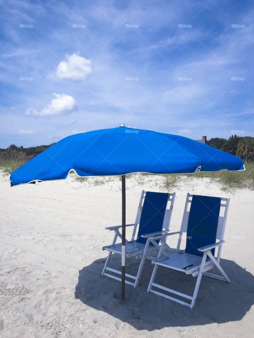 Beach chairs. Two blue beach chairs at the ocean waiting for your relaxation.