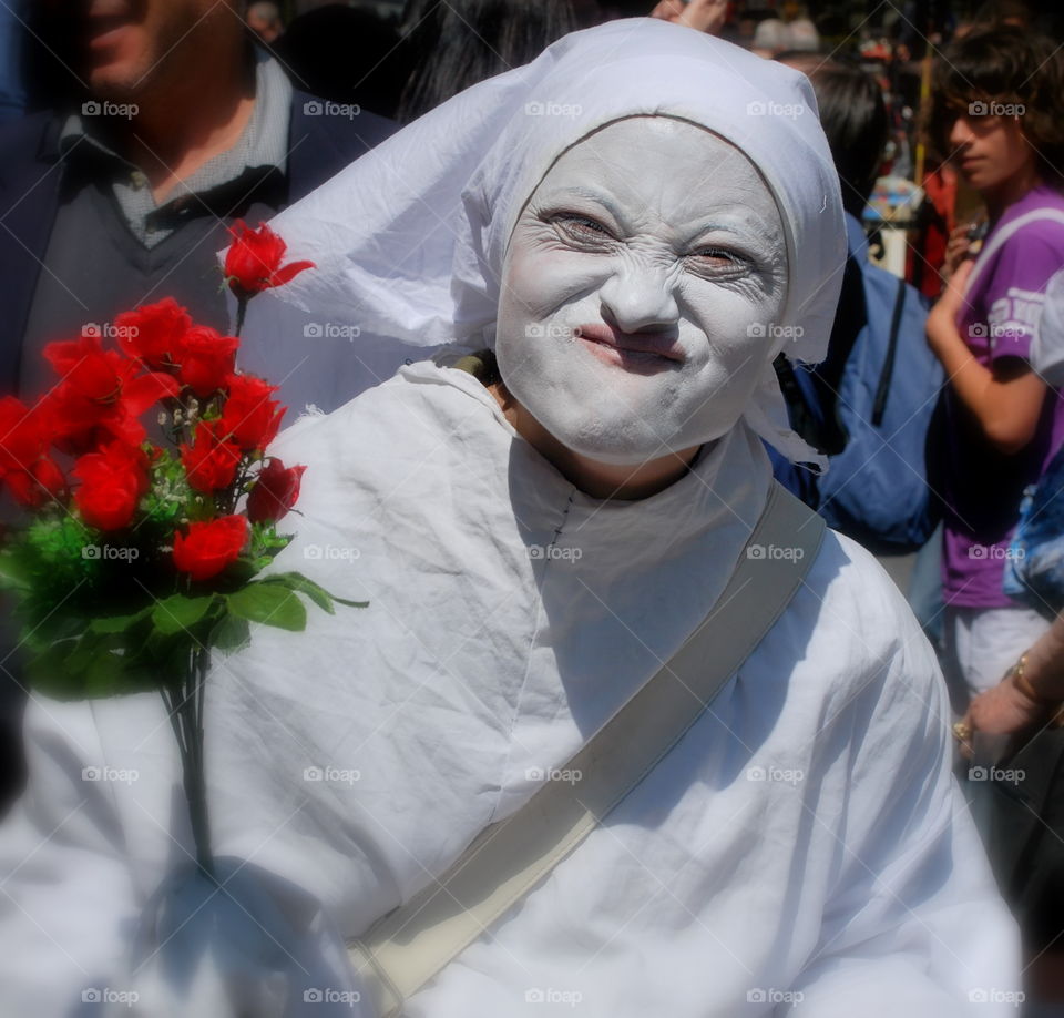 Street woman in Florence. Ladies in white and whiteface approach tourists hawking roses
