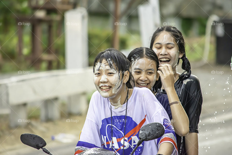 Asian woman Riding a motorcycle play water and flour in Songkran festival or Thai new year in Thailand at Bang kruai, Nonthaburi , April 15, 2019