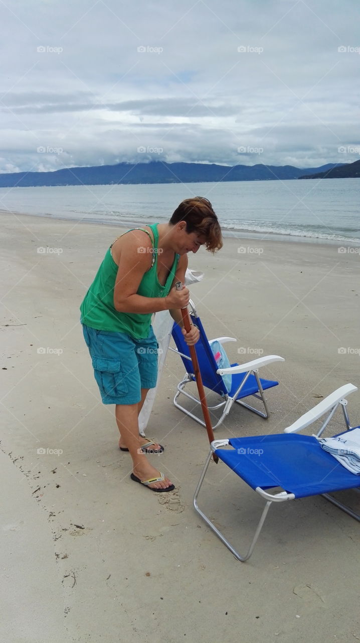 Woman put umbrella in the desert beach 