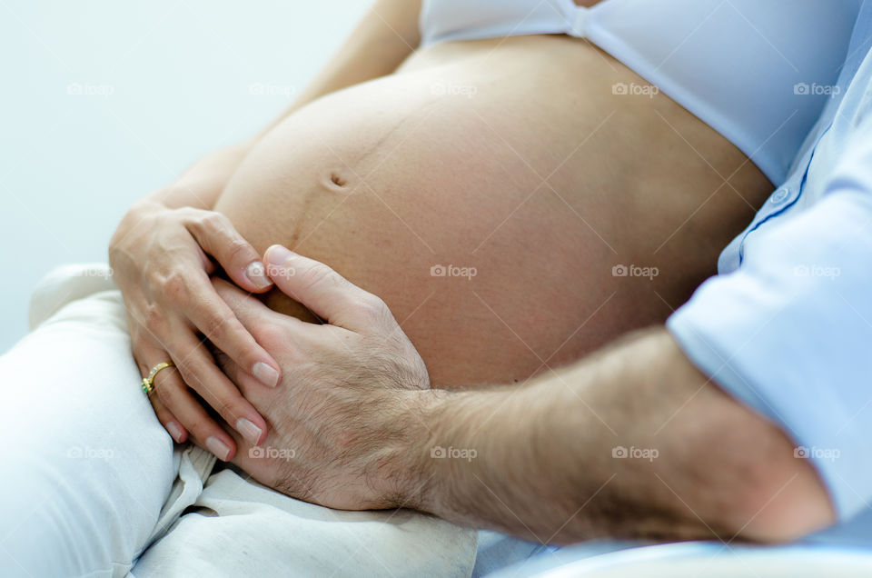 parents caressing pregnant mother's belly