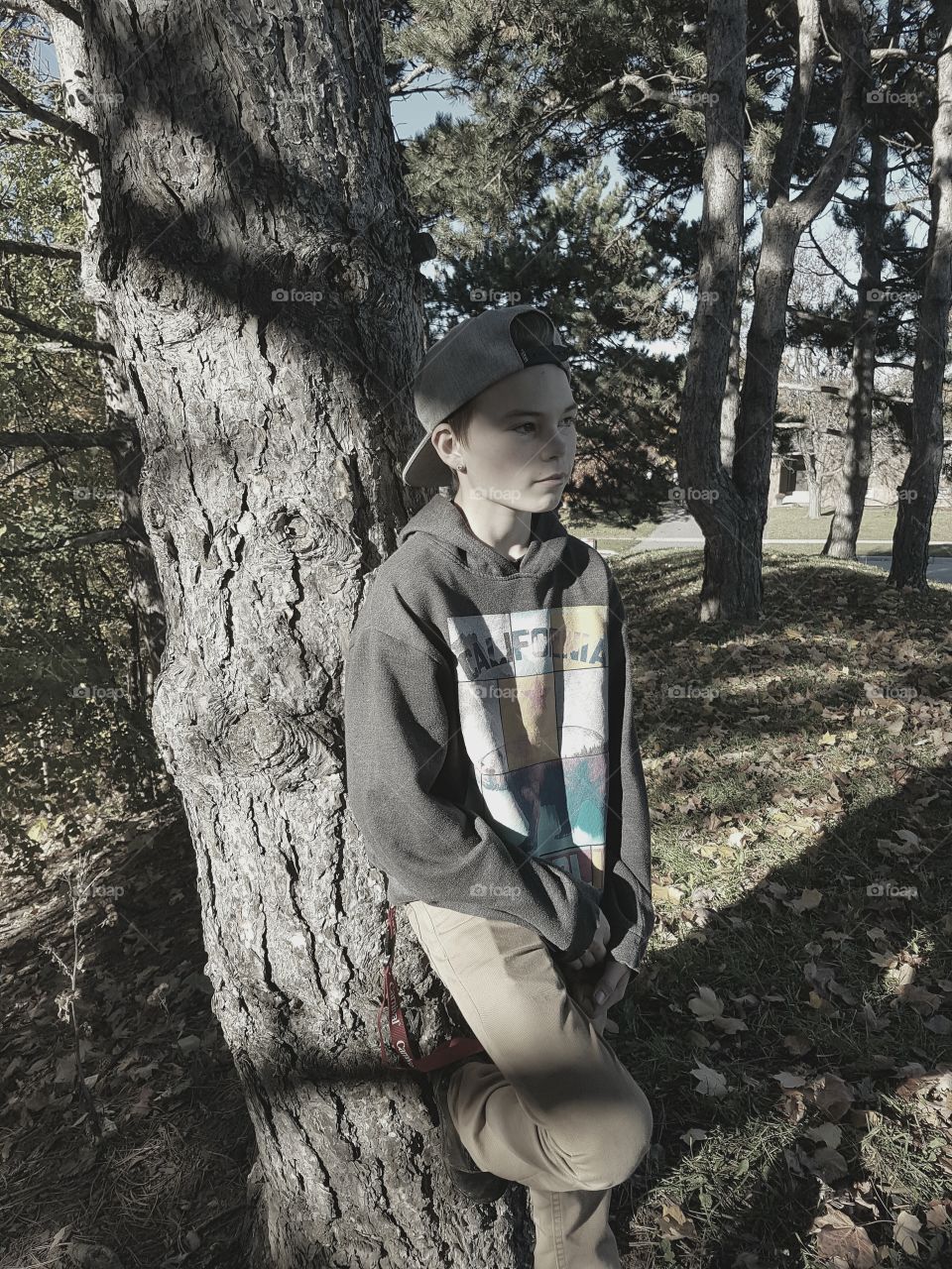teen boy against tree