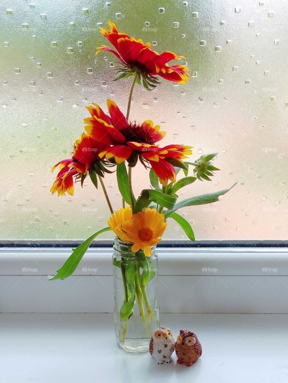 A tiny bouquet in a tiny jar with a couple of tiny owls