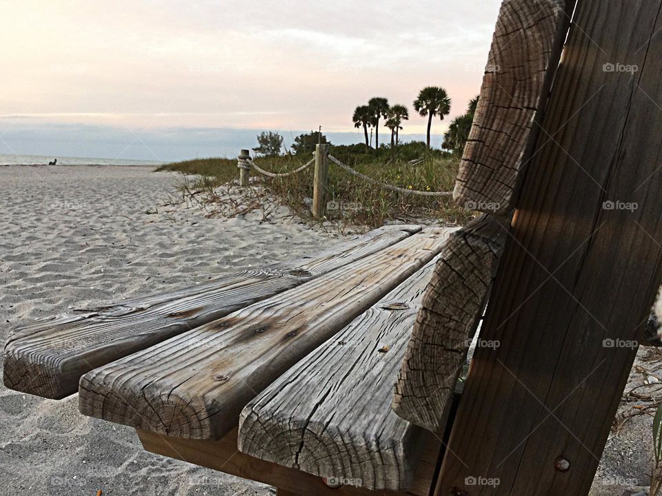 Rustic bench on a pristine beach.