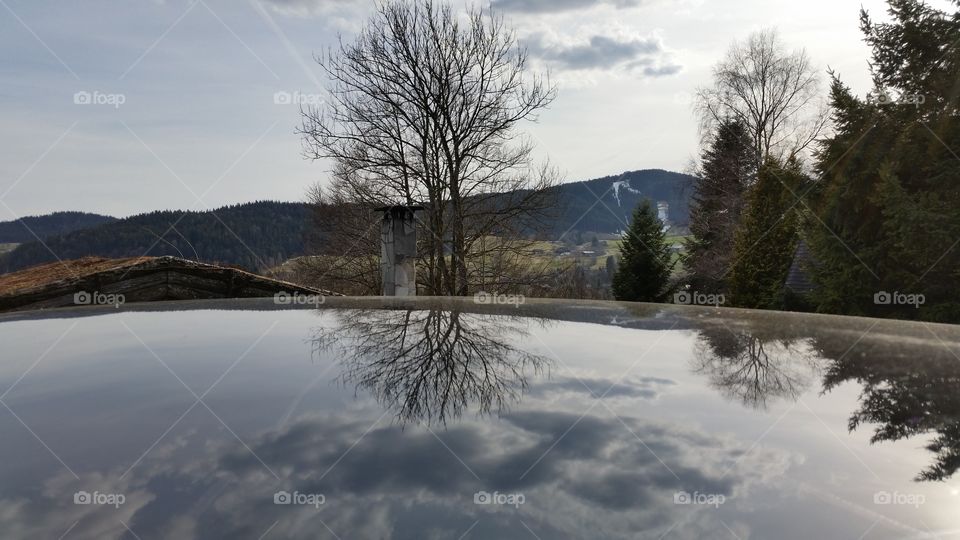 Reflexion on a car's top. Titisee black forest Germany 