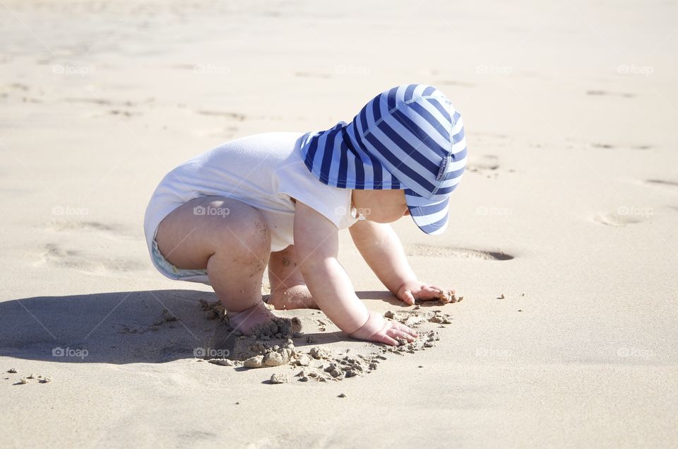 Baby playing in sand at beach