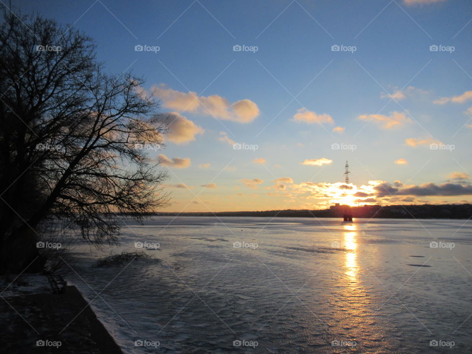 frosty evening in February, sunset and the sky in the clouds, I like to look at the sun going beyond the horizon in winter