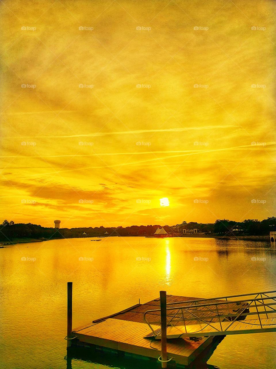 A golden sunrise over the lake and pier at Cranes Roost Park in Altamonte Springs, Florida.