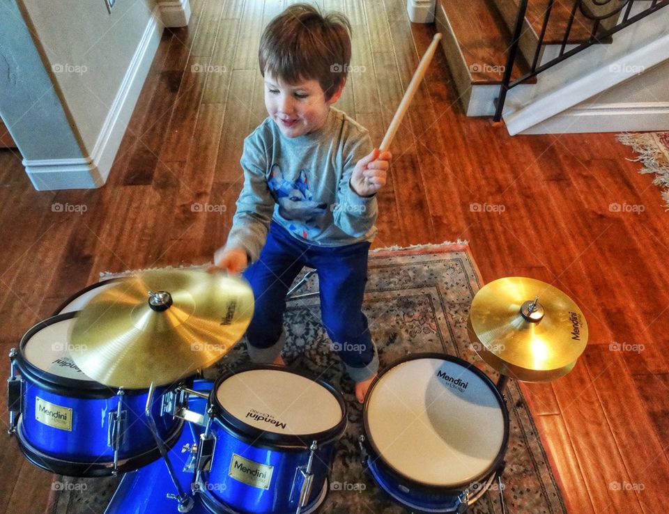 Boy Banging Drums. Young Boy Practicing On A Drum Set
