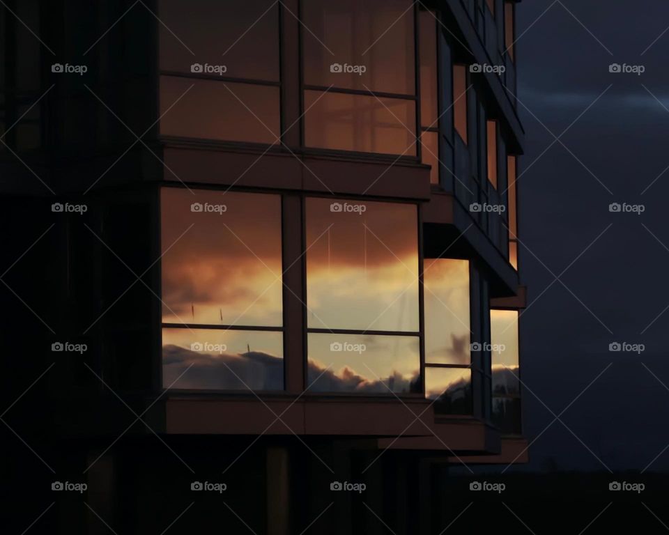 A reflection of sunset and sky in a skyscraper 