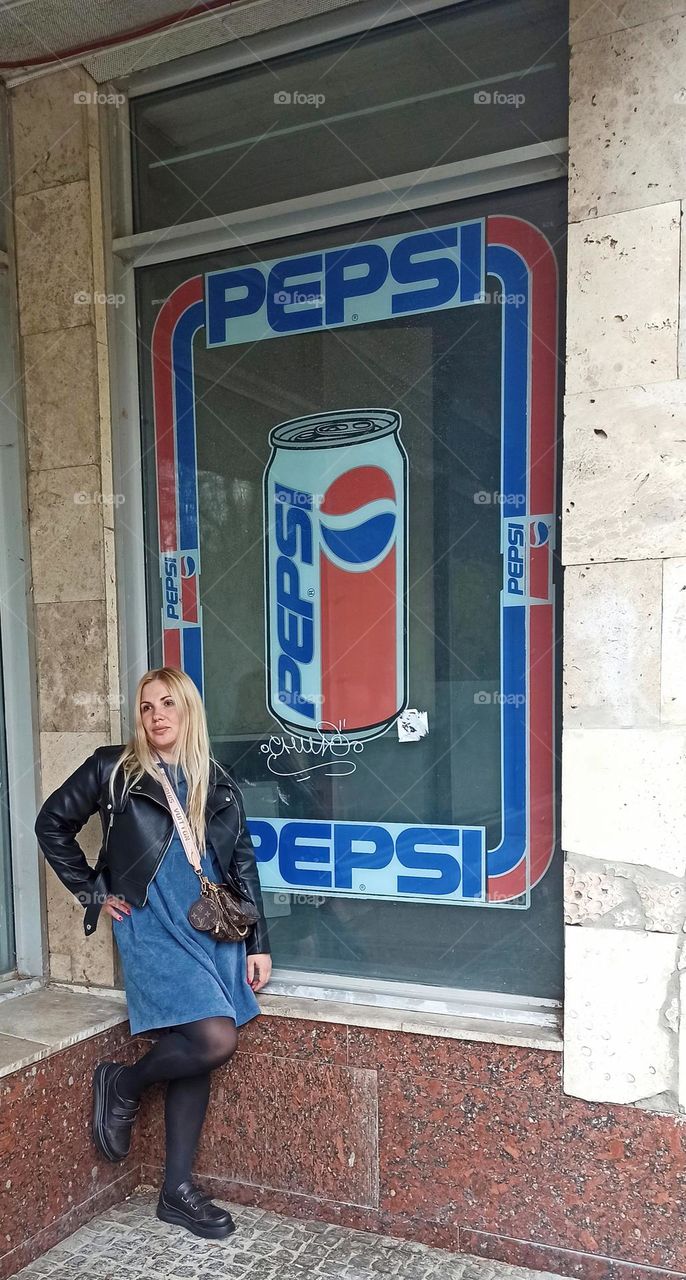 girl standing near pepsi advertisement