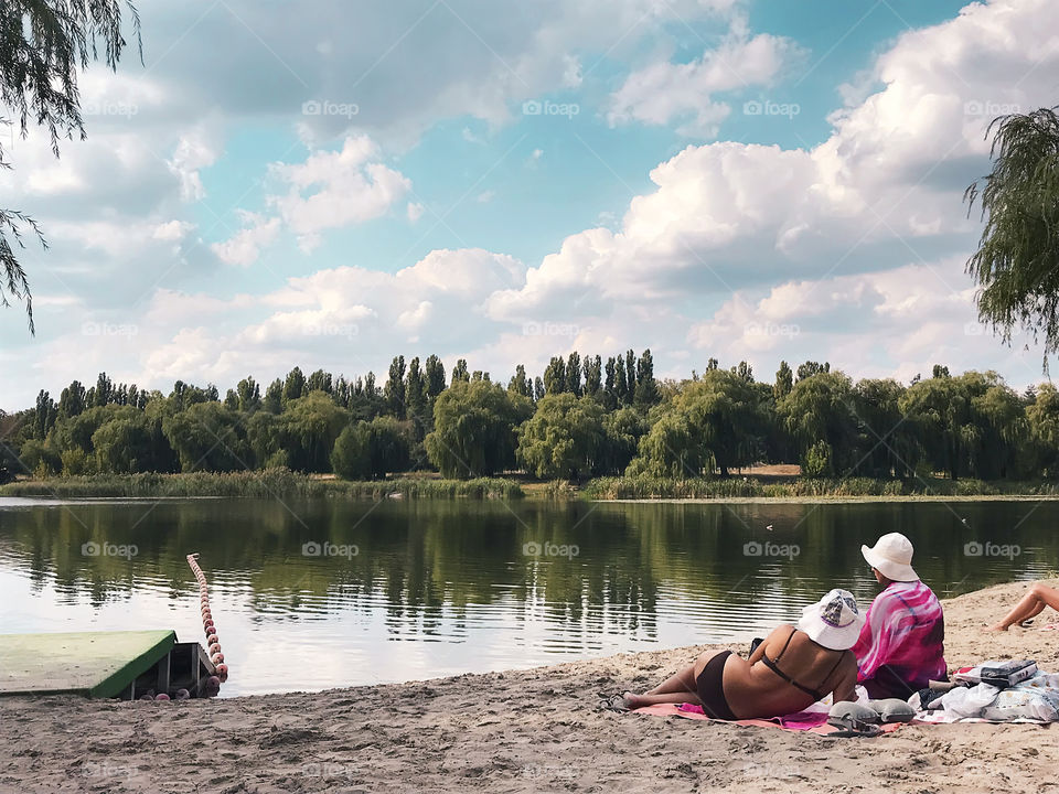 People enjoying the calmness of nature at the beach at the local lake in the countryside 