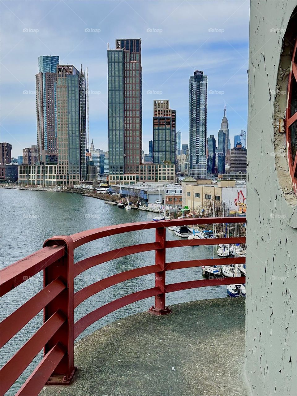 This is “Newtown Creek”, an ocean inlet of the “East River” seen from the central outpost of the “Pulaski Bridge” that connects “Greenpoint”, Bklyn to LIC. Across the water we see “Manhattan” incl. the “Empire State Bldg”. 2024. Hypnotic Productions