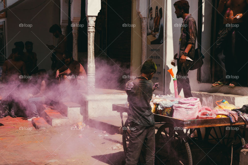 A child street vendor throws pink powder at Holi festival in Pushkar, India.