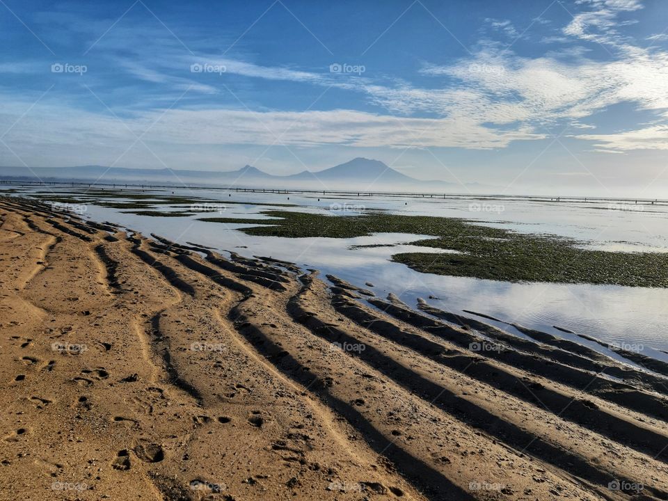 a morning view of a mountain that was taken from the beach