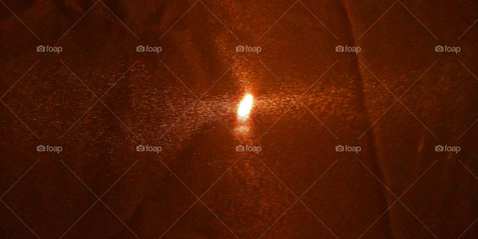 Candle behind a thin curtain