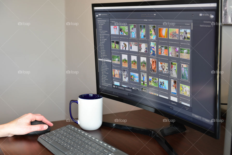 Woman sitting at a desk while editing pictures on a computer monitor