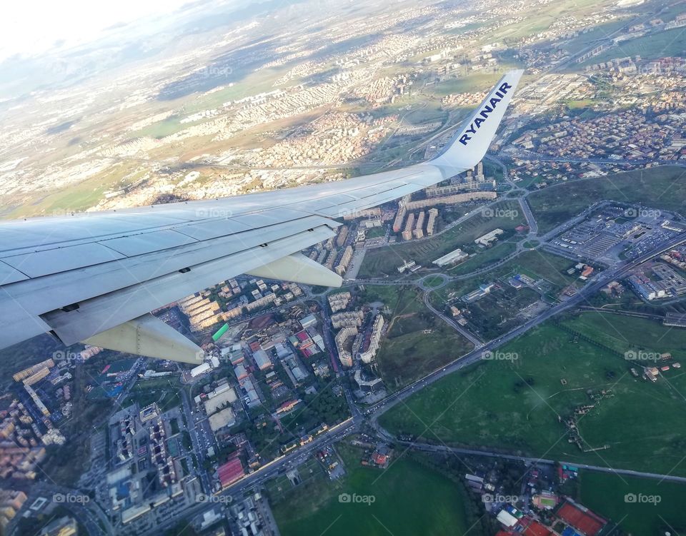 Airplane wing in the foreground and panorama seen from above