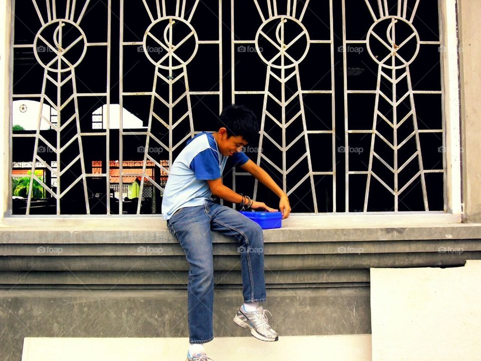 Boy playing with his toys by a window