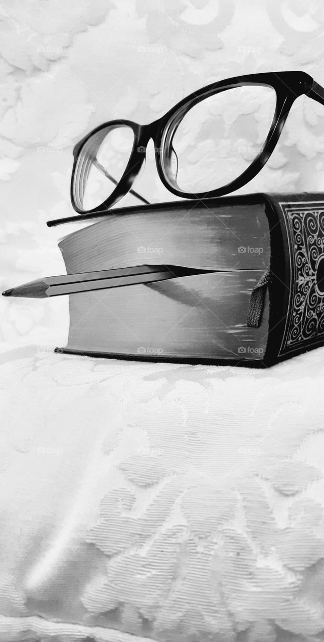 book with pencil and eyeglasses