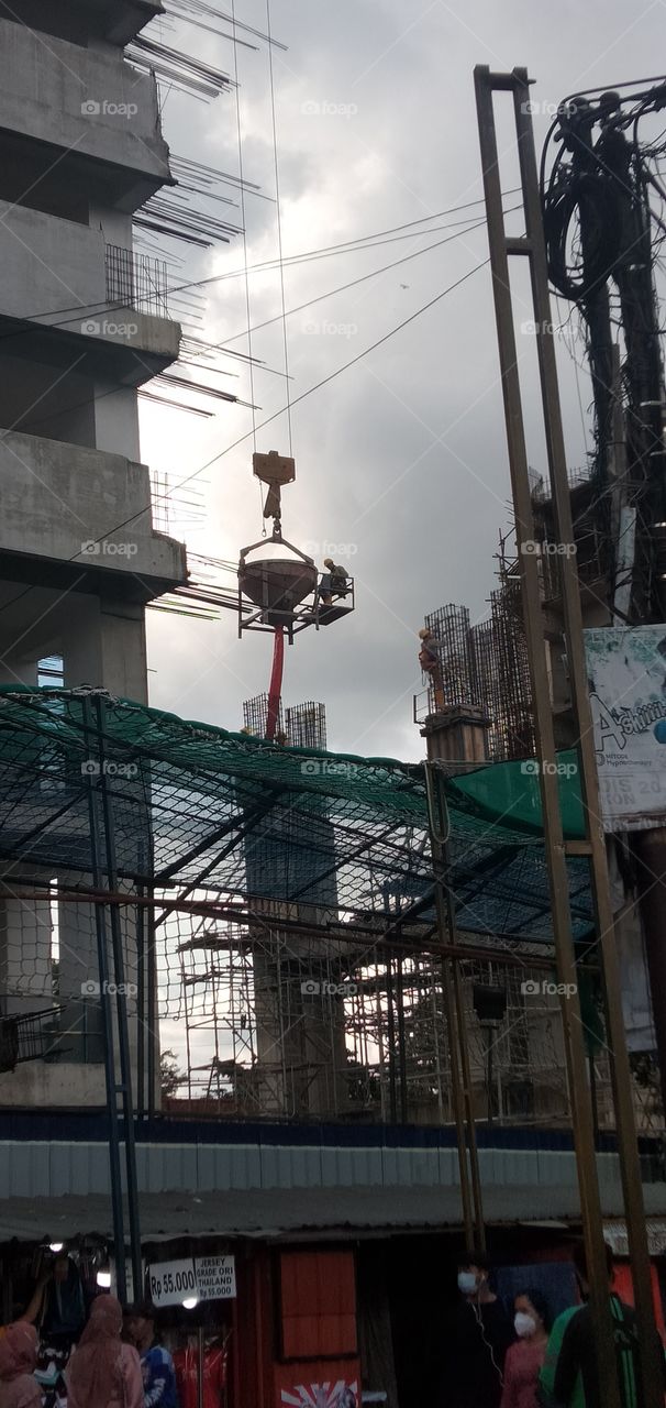 New construction of a building: filling concrete liquid into column beams.