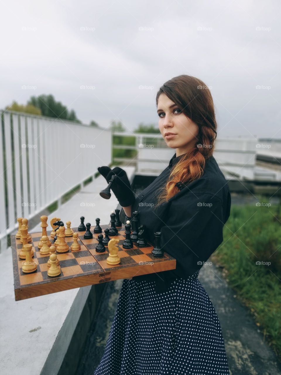 Девушка  позирует с шахматами.Фото в готическом стиле