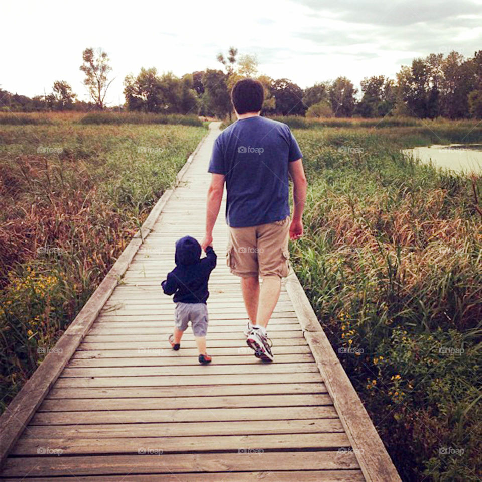 Father and son. father and son holding hands on a walk through local Nature Reserve