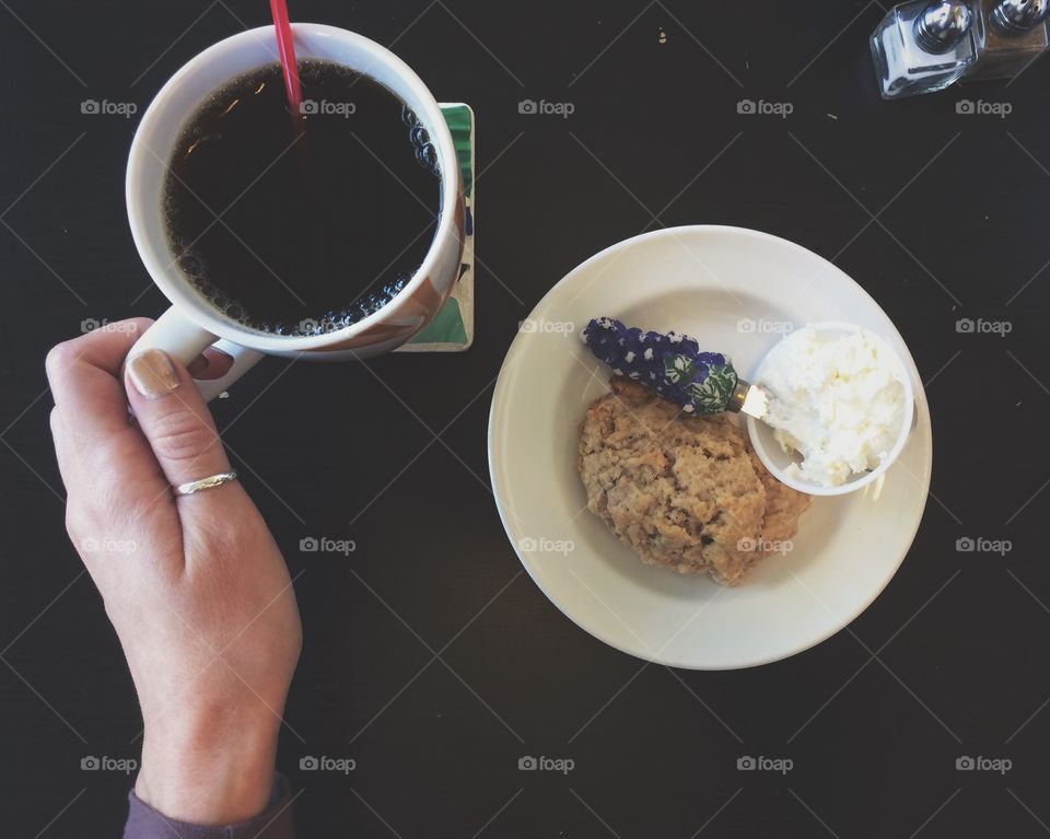 Having coffee and a scone in a cafe.