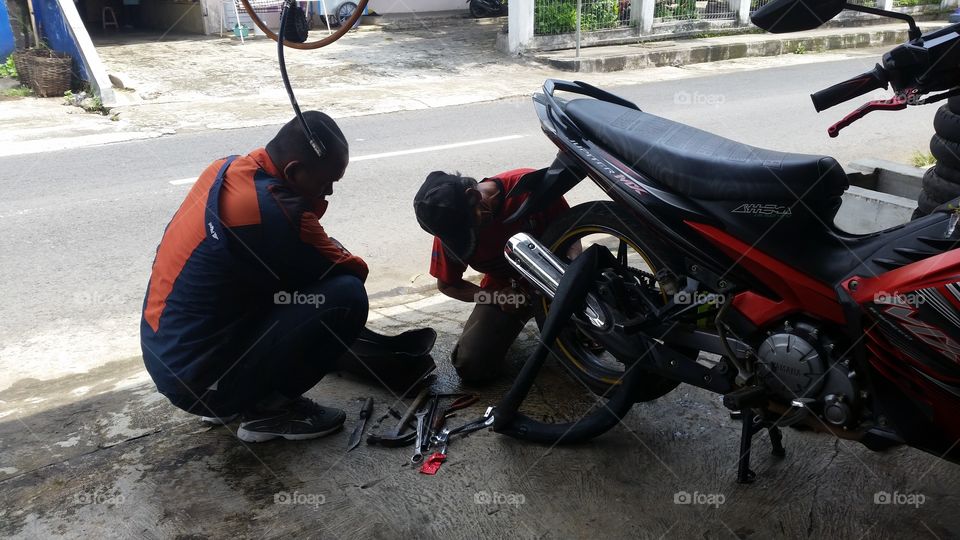 a mechanic who is repairing a motorbike