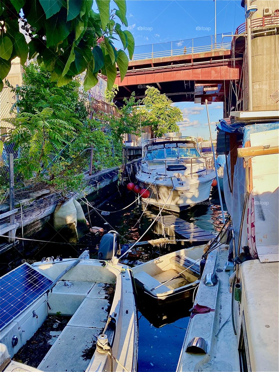 This is “Newtown Creek” with a view of the “Pulaski Bridge” in LIC, Queens and all the different kinds of boats that are tied to the bulkheads here. The setting sun lends a warm golden glow to everything here. 2023. Hypnotic Productions