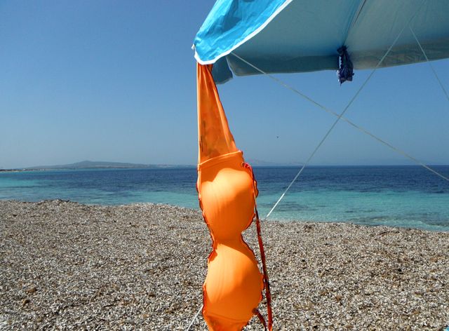 orange color story: orange bikini drying in front of sea