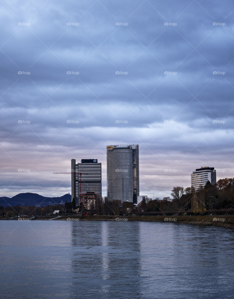 View of the Post Tower and United Nations building from the Rhine river at dusk.