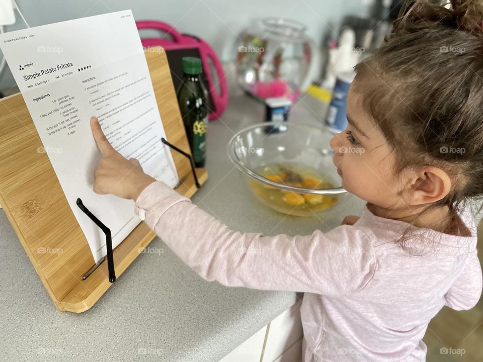 Toddler reads recipe for potato frittata, cooking with mommy, toddler helps mommy in the kitchen