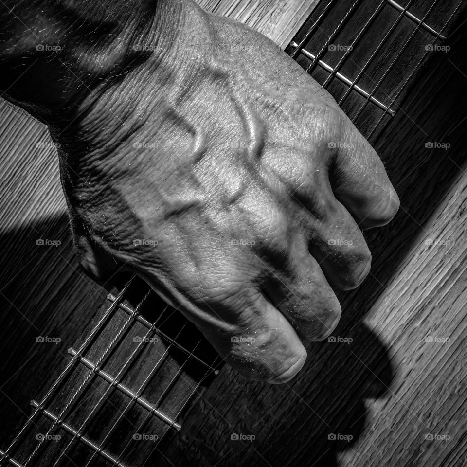 Guitar string pulses pass through the veins of the hands