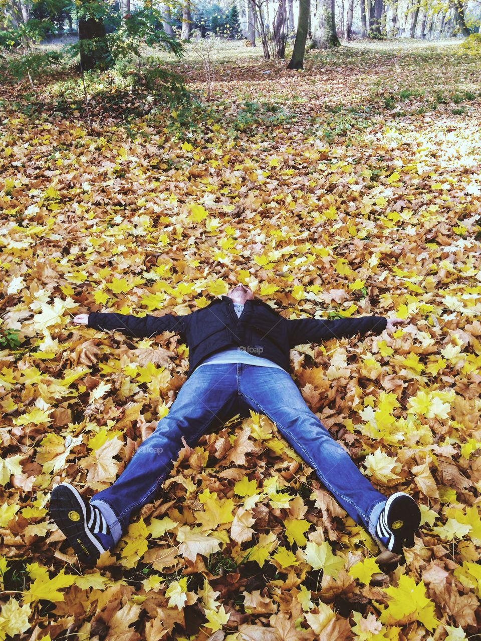 Man lying on autumn leafs