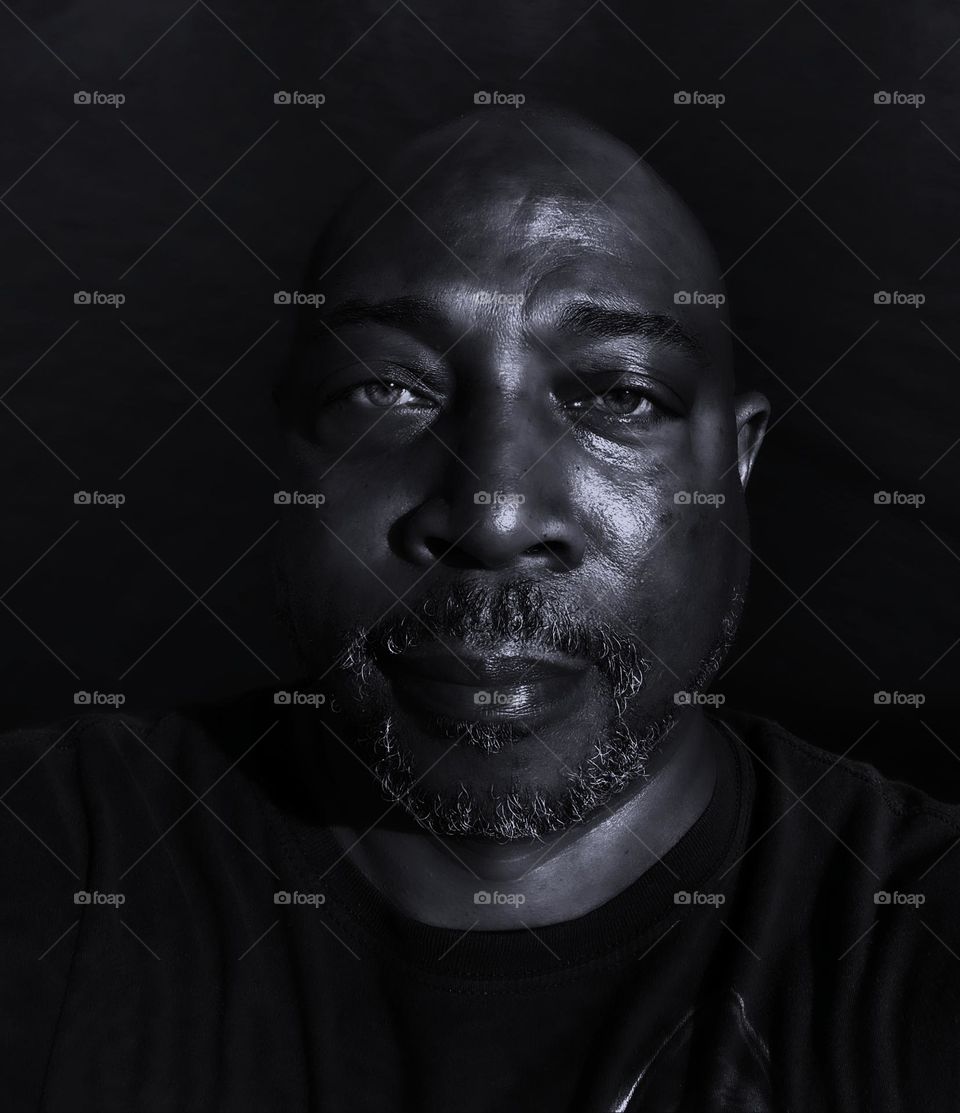 Black-and-white portrait of a man with a bald head and a Gray beard